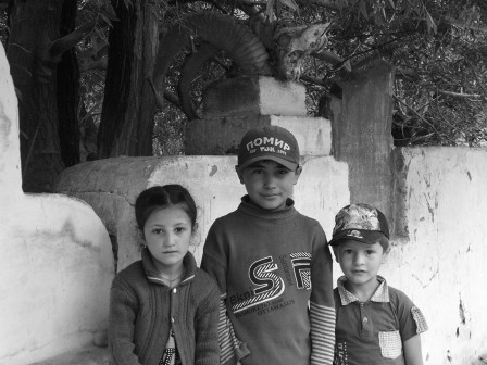 Jeunes Pamiris devant le mur d'un mazar (un petit mausolée) entre Zumgud et Vrang