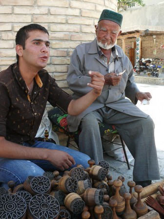 Le petit-fils discute le prix des kitchaks de son grand-père avec les touristes