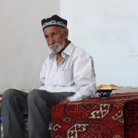 Boukhara. Aksakal prenant son thé devant une échoppe de tapis
